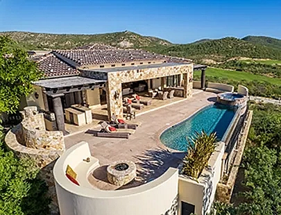 aerial view of a large home with a pool and fire pit