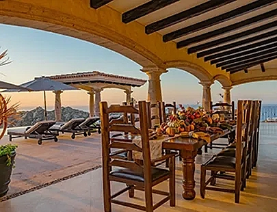 large wooden dining table with a view of the ocean