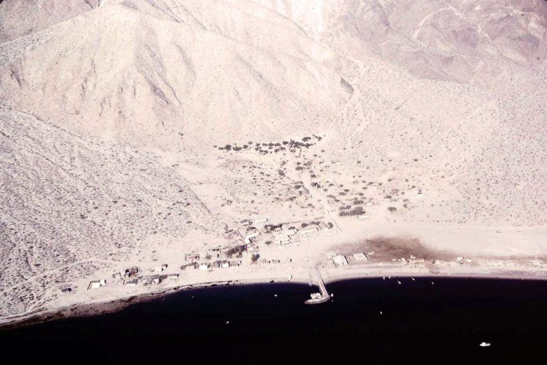 Bahia de los Angeles - Baja California, Mexico in 1972. The runway parallels the beach above the buildings to the right of the pier.	