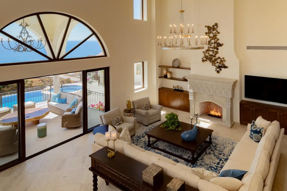Cabo San Lucas luxury vacation rental Casa Stella living room with fireplace and sliding glass doors to pool terrace